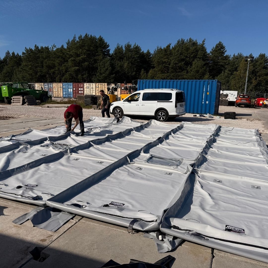 tent on ground being set up by a couple people
