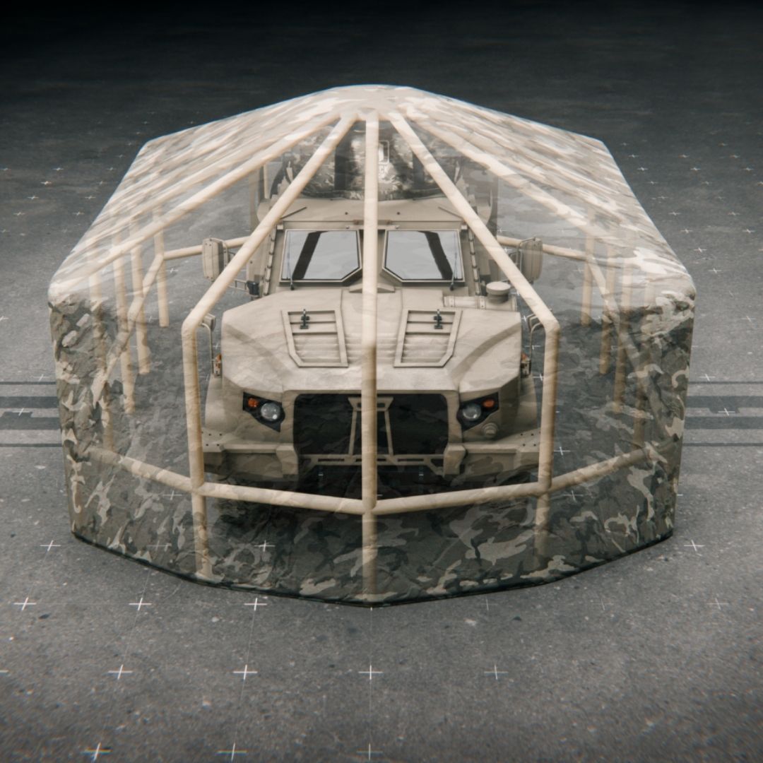 High-angle view of the light tactical vehicle completely enclosed within the expansive, faceted geometric structure of the fully extended Black Widow hide. The frame creates a large canopy, integrating the base netting.